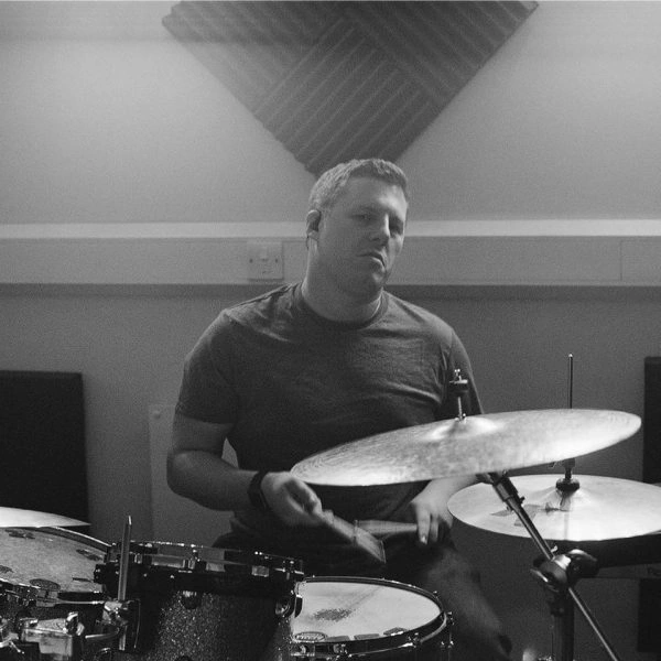 Greyscale image of josh playing drums in the studio